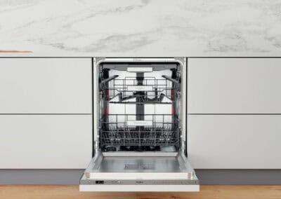 Lavastoviglie integrata in cucina moderna con ante bianche e piano in marmo.