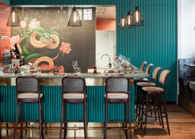 Bar con decorazione di un drago cinese e sedie in legno.