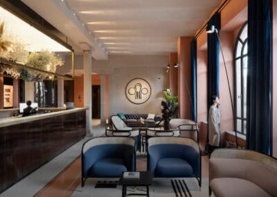 Interno raffinato con sedie blu e arredi di design, atmosfera calda e luminosa.