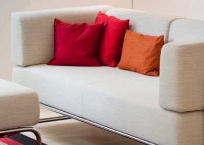 Divano moderno con cuscini rossi e arancioni, arredamento elegante e confortevole.